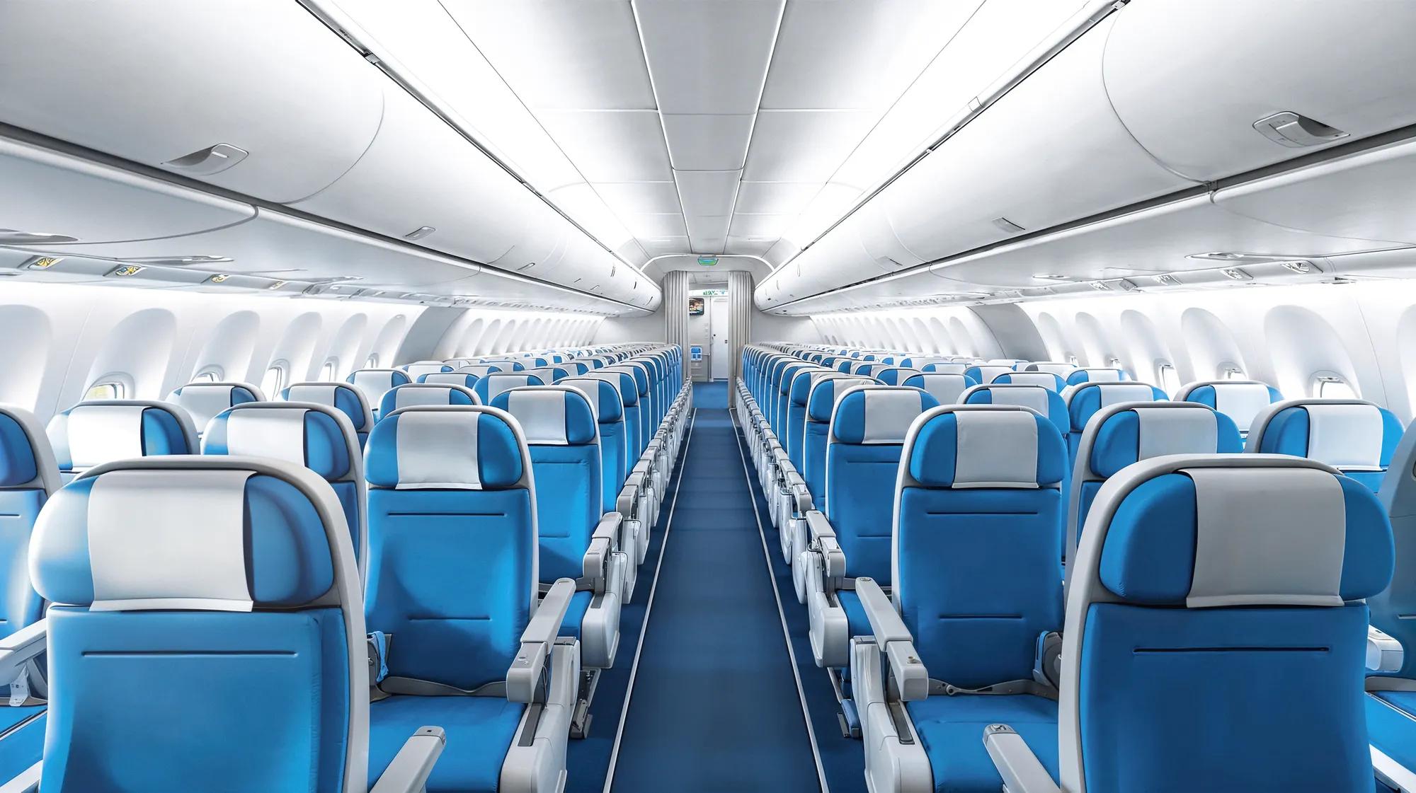 Interior of empty modern aircraft with blue flight seats and hallway in daytime during flight