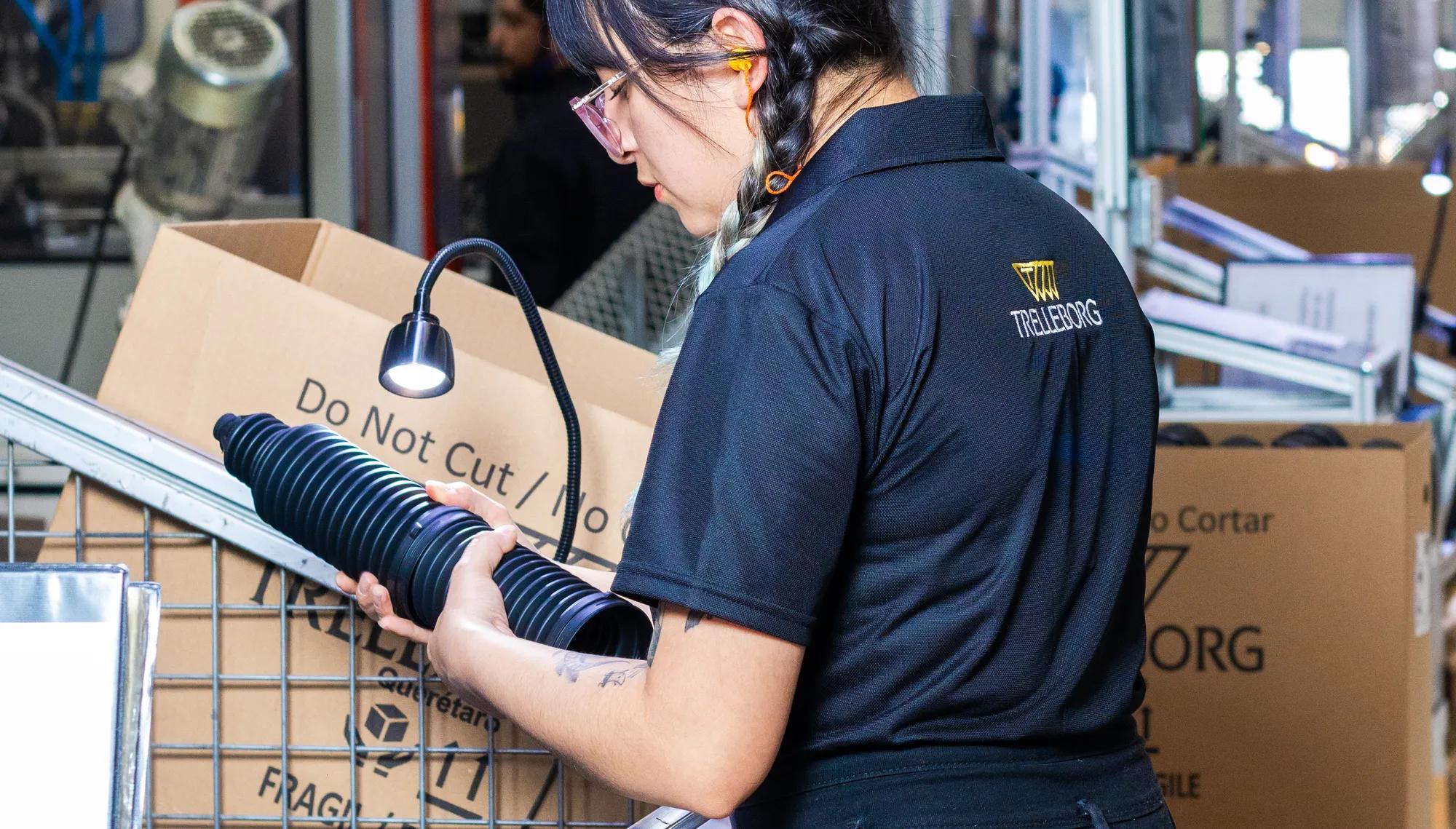 Trelleborg operator packaging rack-and-pinion boots after completing a quality inspection.