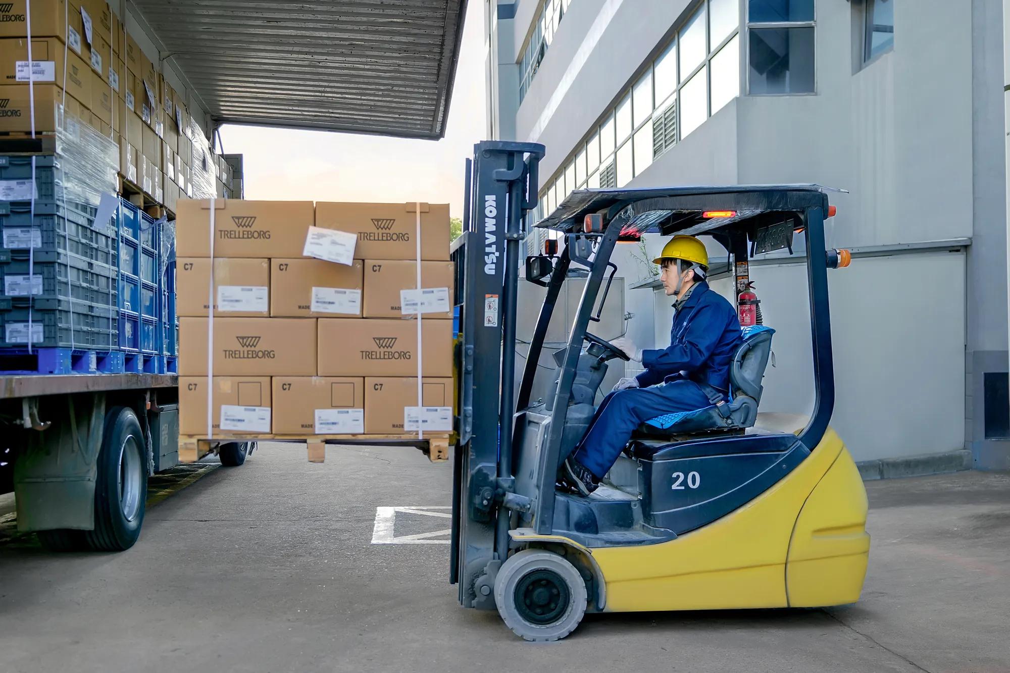 A Trelleborg Wuxi Boots employee loads a cargo truck with steering and transmission boots for the automotive market.