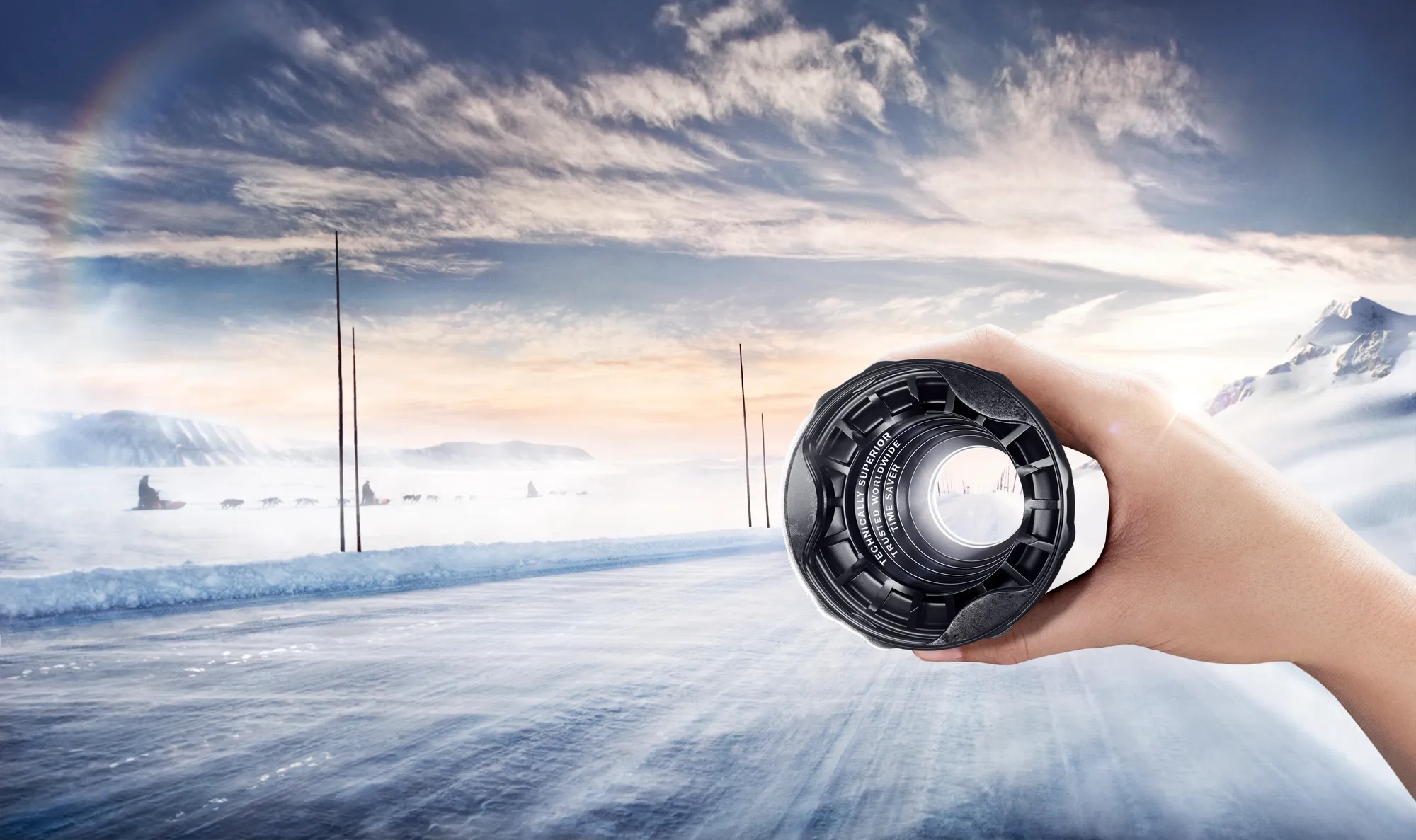 Trilobe bellows shown from the large‑diameter side, held in a hand with a winter countryside landscape in the background.