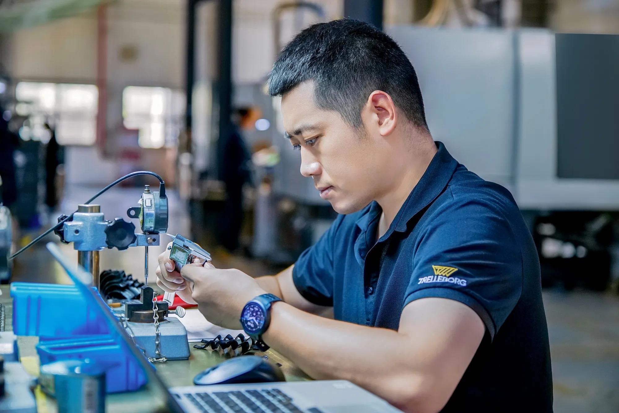 An employee uses metrology instruments to analyze part thickness.