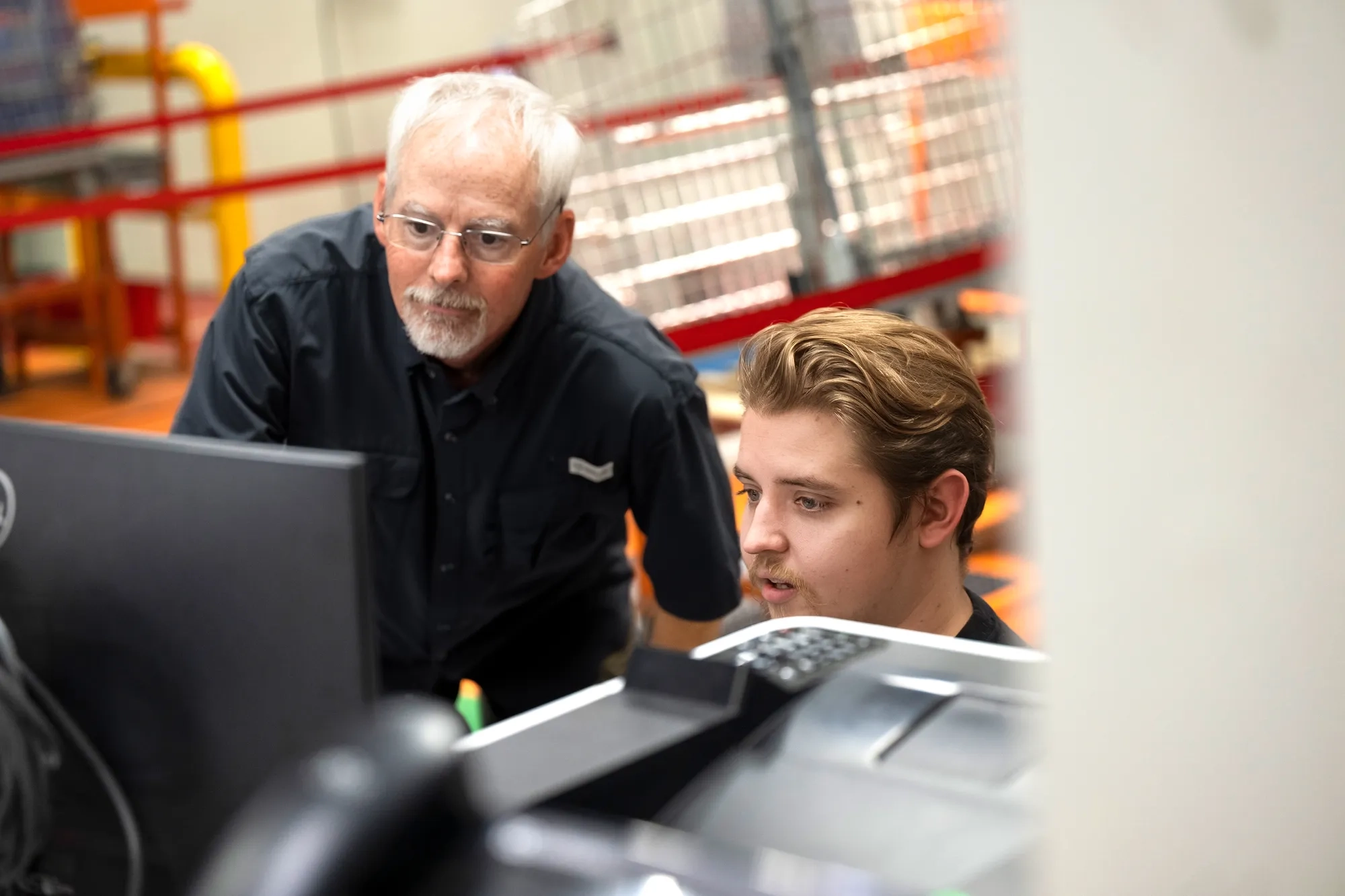 Two employees discuss work at a computer on the shop floor of the Salisbury facility.