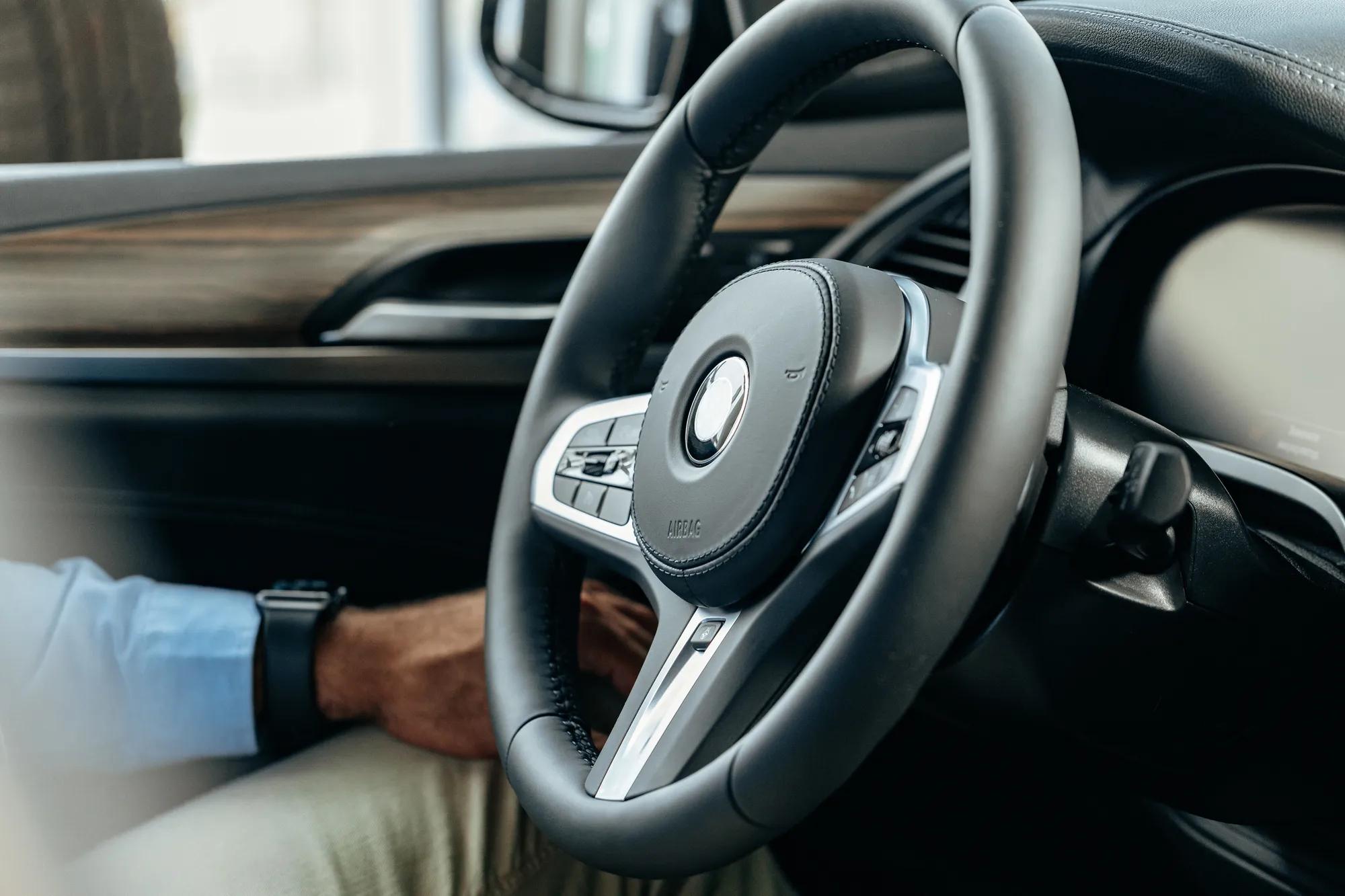 Male hands holding steering wheel of a car close up