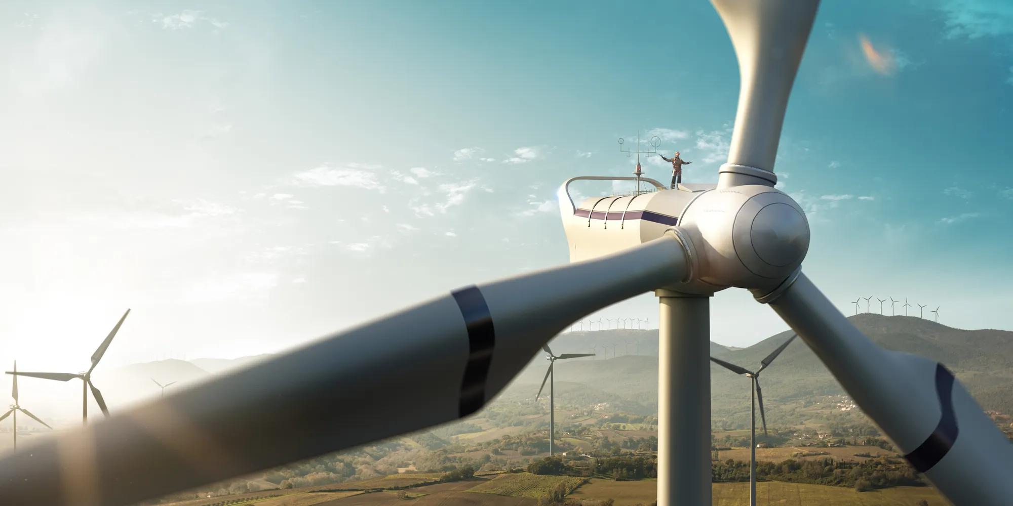 Happy engineer feel success after good work. He standing a top of windmill and looking beautiful sunset landscape