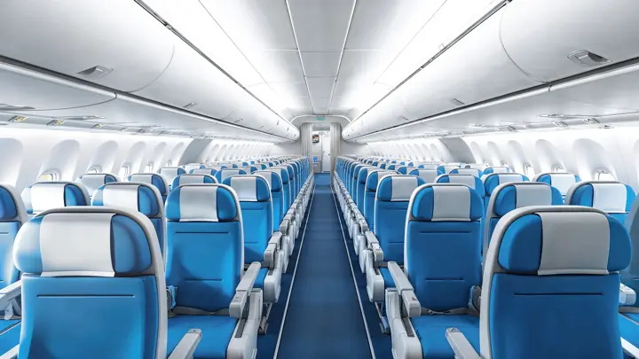 Interior of empty modern aircraft with blue flight seats and hallway in daytime during flight