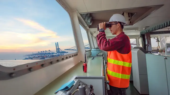 duty officer in charge handle of the ship navigating to the port destination, keep watching navigation on the bridge of the ship vessel under voyage sailing to the sea