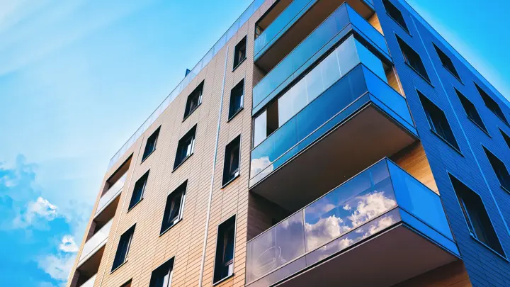 Modern residential apartment and flat building exterior. Part of New luxury house and home complex. City Real estate property and condo architecture. Copy space. Blue sky