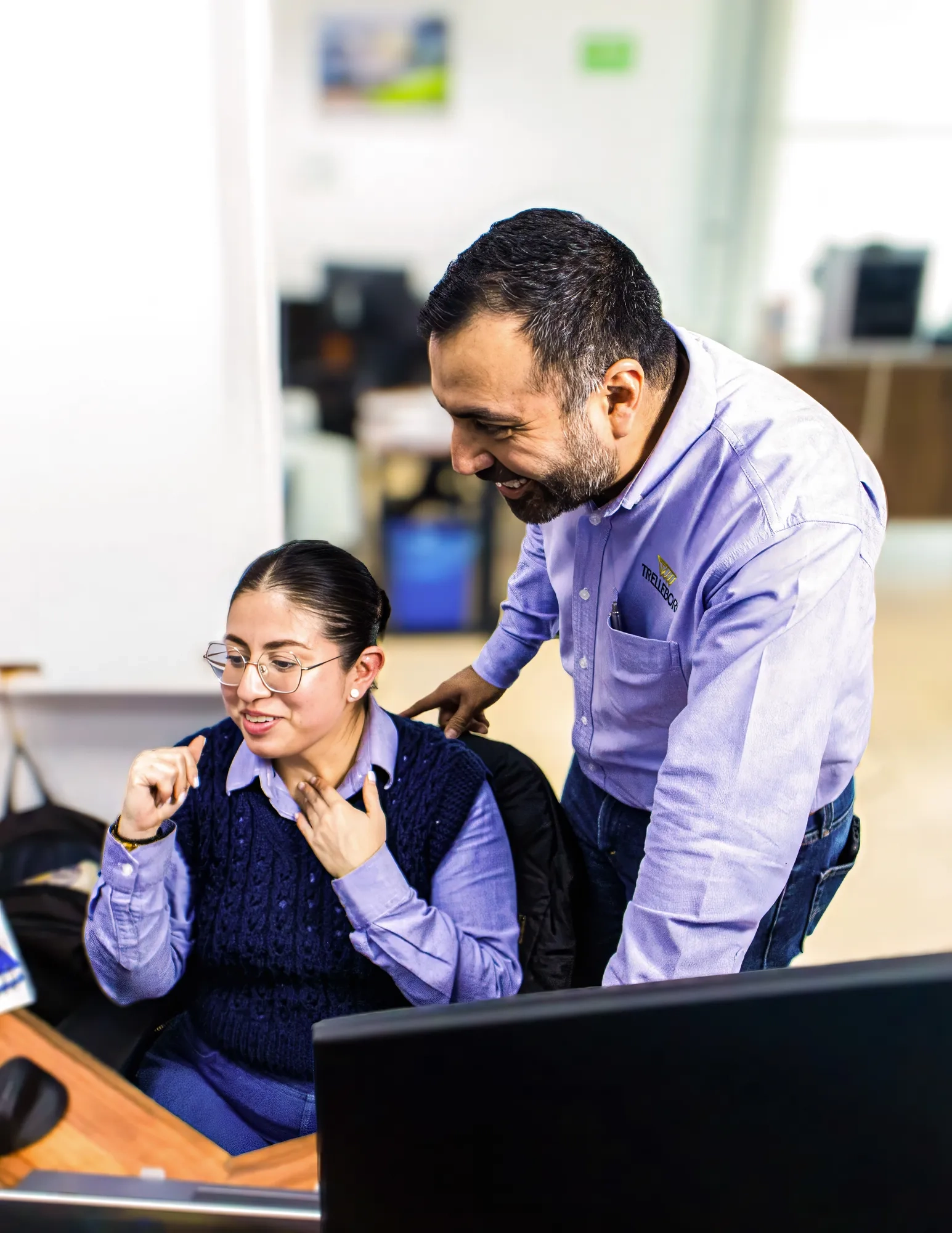 Two collaborators reviewing and discussing data at one employee's desk.