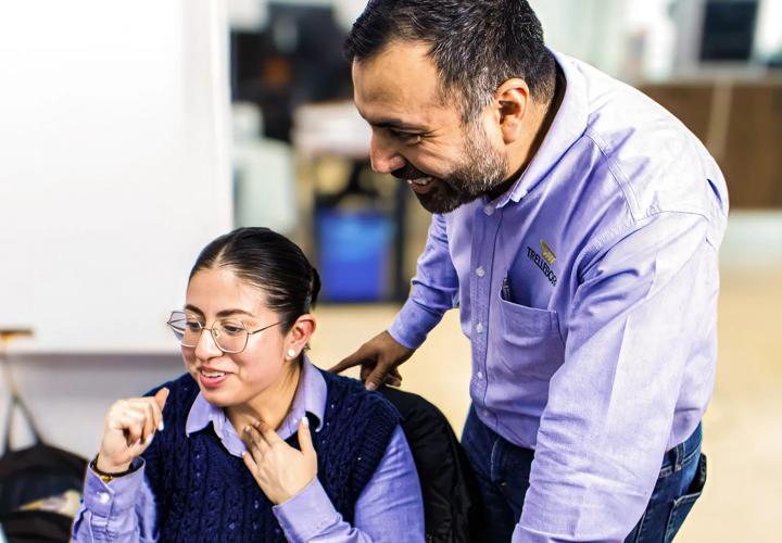 Two collaborators reviewing and discussing data at one employee's desk.