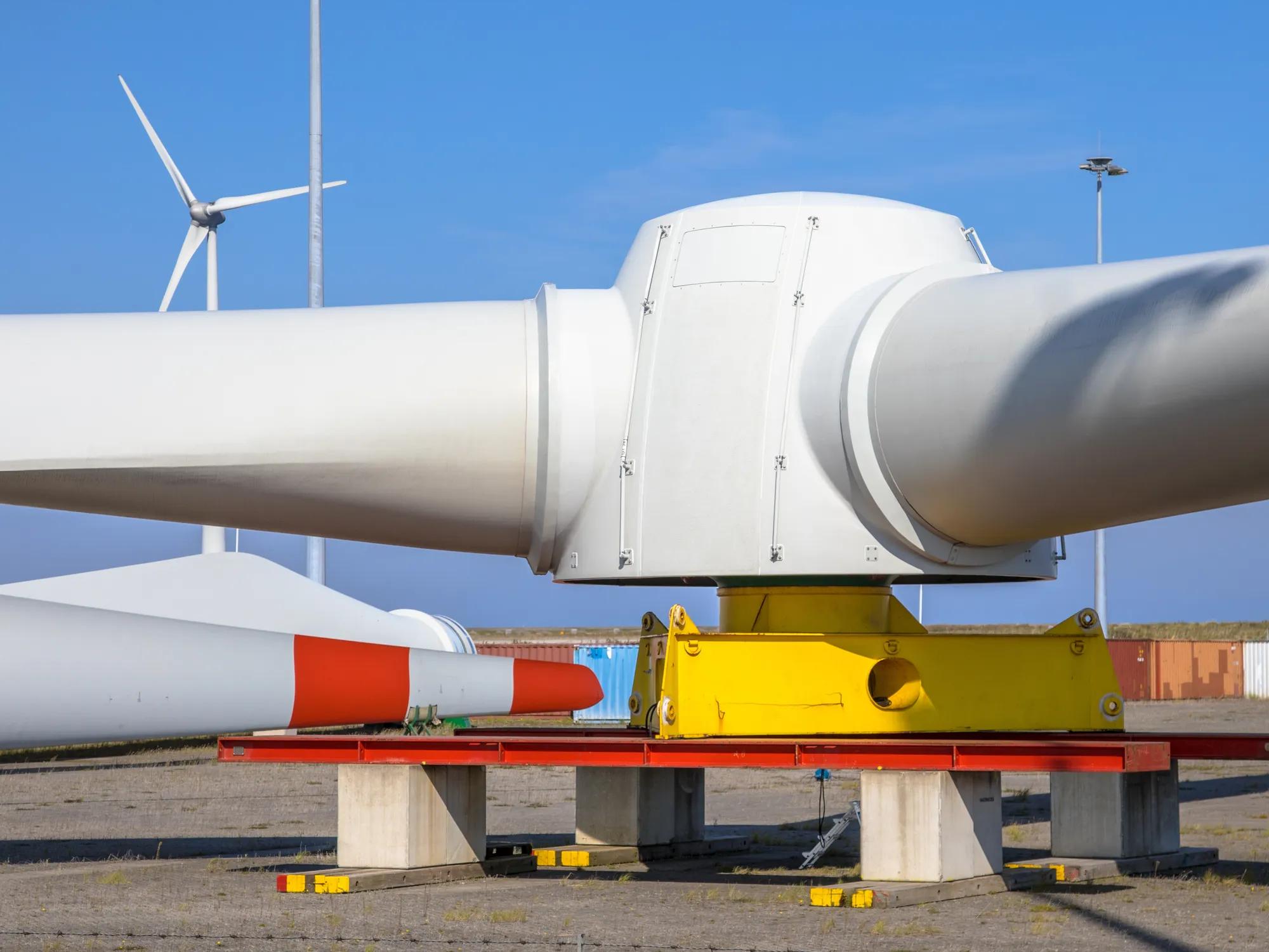 Giant rotors of wind turbine on windmill construction yard to build windfarms at sea, under clear blue sky