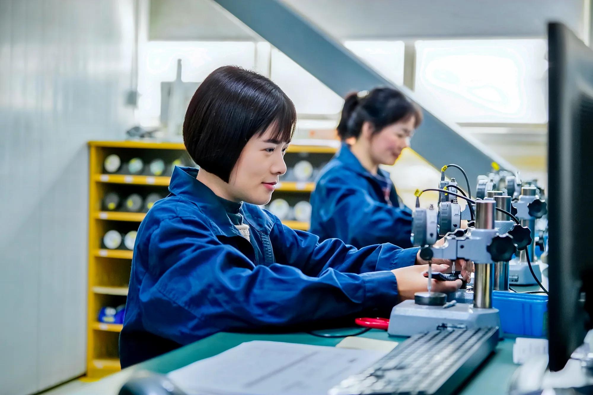 Two employees from the metrology department inspect parts in detail to analyze the thickness and shape of the bellows.