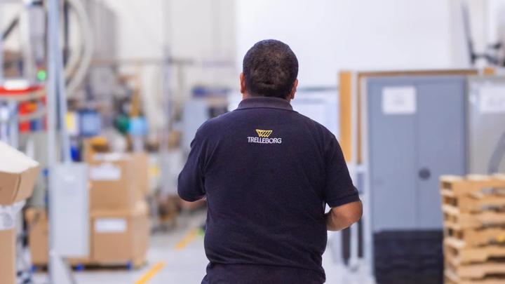 An operator wearing Trelleborg workwear walking across the production floor.