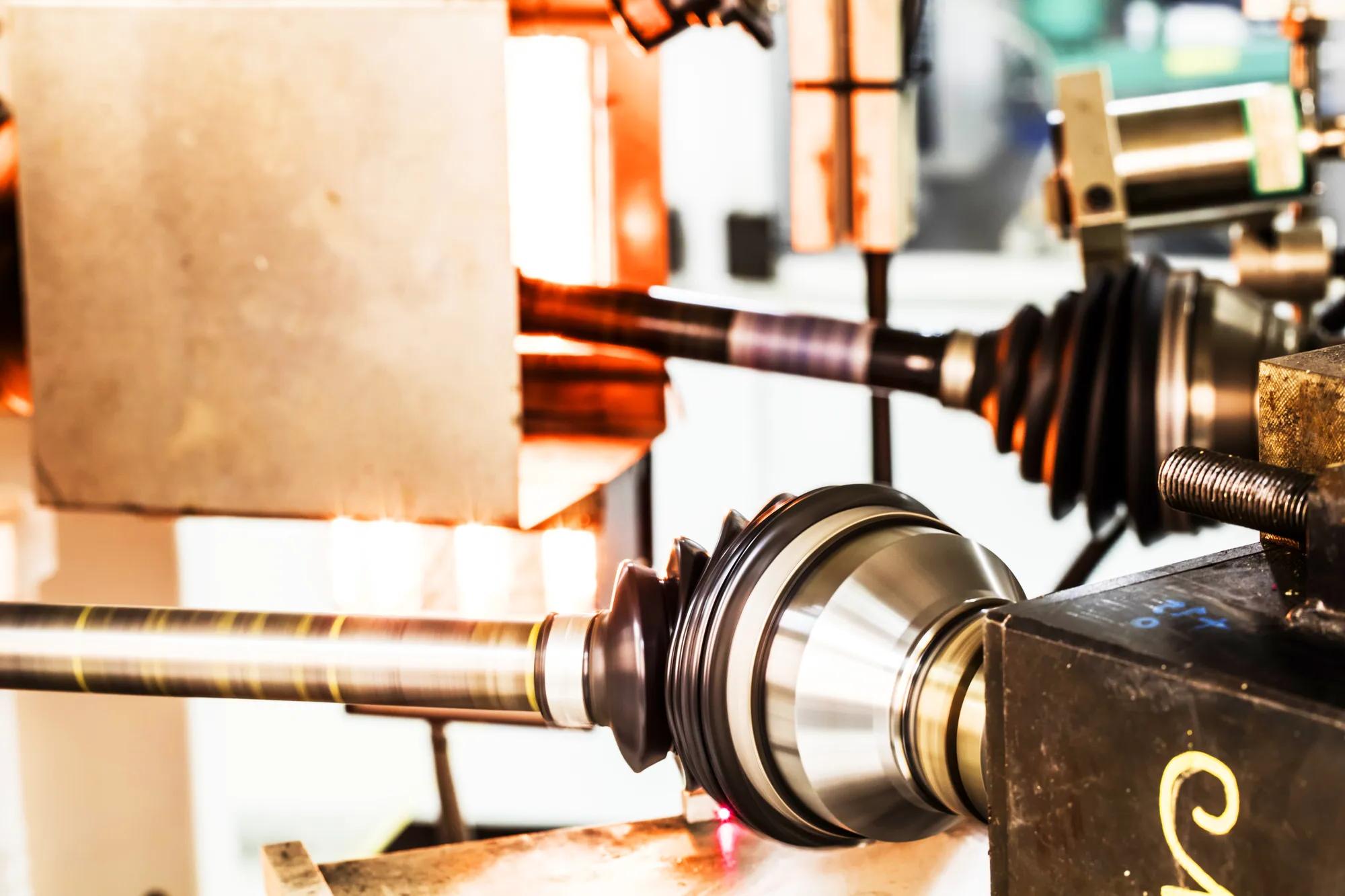 Constant Velocity Joint (CVJ) boot being tested on a high-temperature bench rig at an angle to evaluate its resistance to heat, rotation, and mechanical stress.