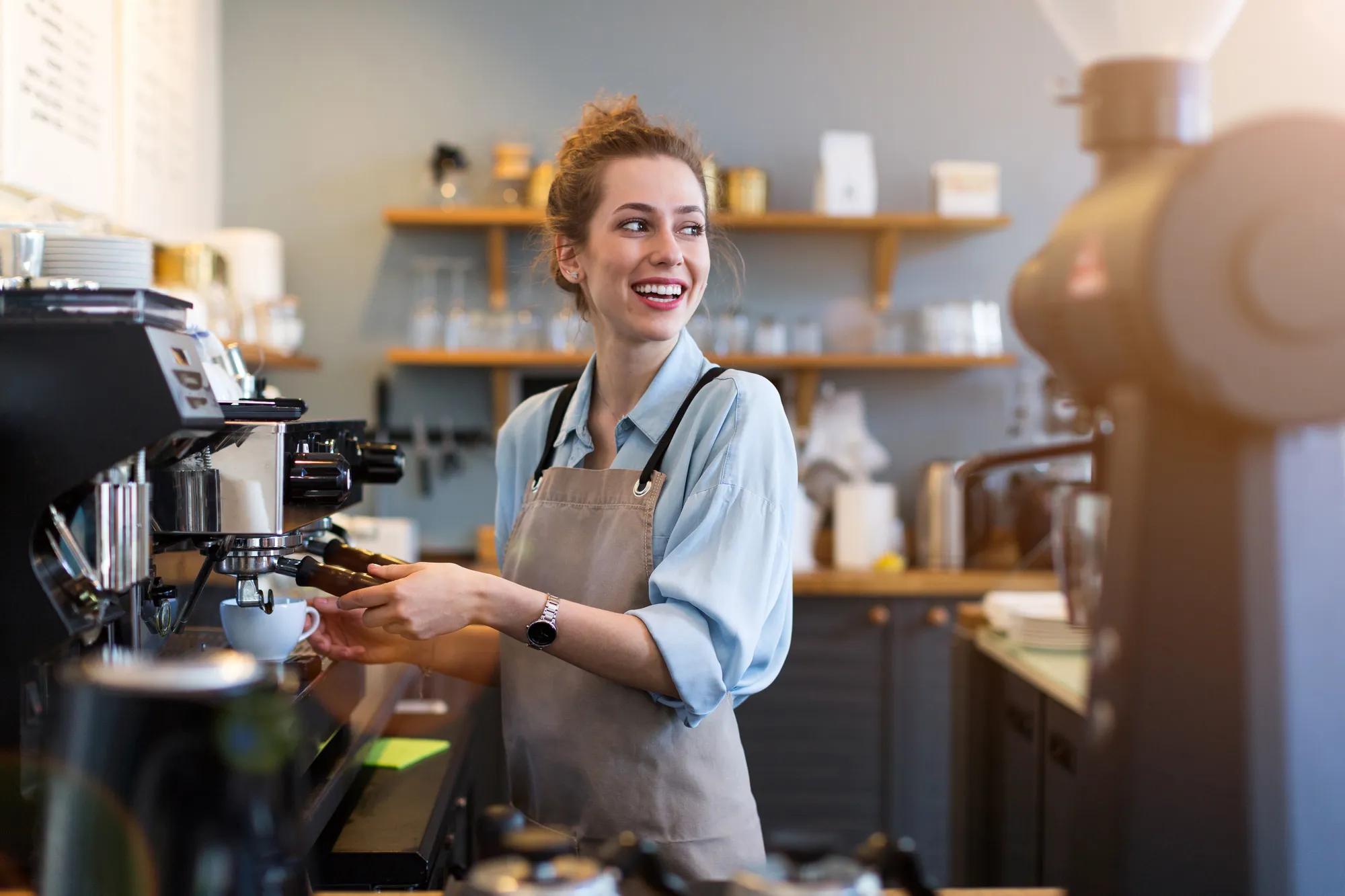 A female owner making coffee in her cafe
