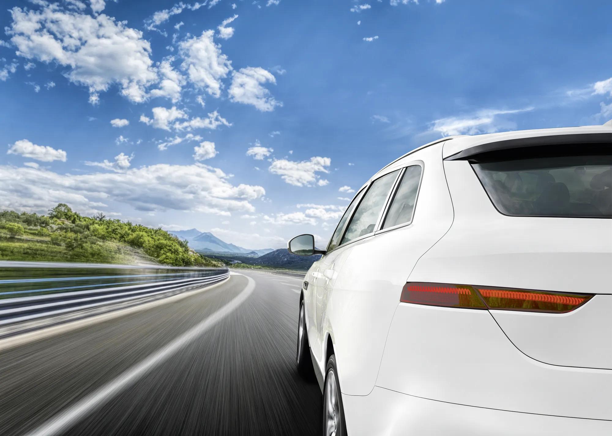 Red car rushing along a high-speed highway. Toned photo.